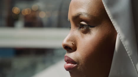 african-american lady in hijab looks around in shopping mall