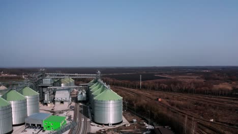 metal silos on field aerial view. large containers for storing and processing grains. silver grain elevators in farmland. storage tank view from above. silo with grain.