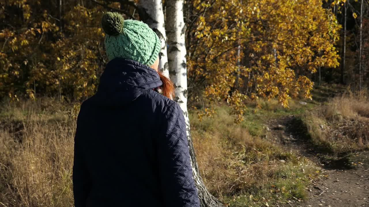 mujer caminando por el camino del bosque en paz, disfrutando de la naturaleza en otoño