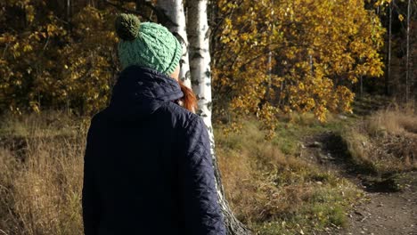 Mujer-Caminando-Tranquilamente-Por-El-Sendero-Del-Bosque,-Disfrutando-De-La-Naturaleza-En-Otoño