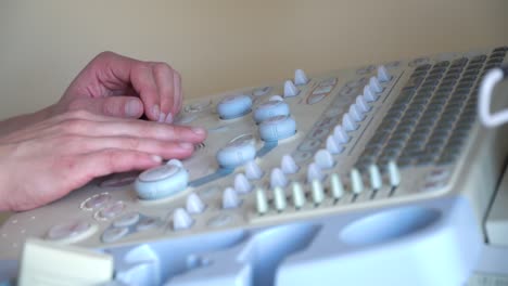 close up of hands of young doctor working on ultrasound device. diagnostics covid 19