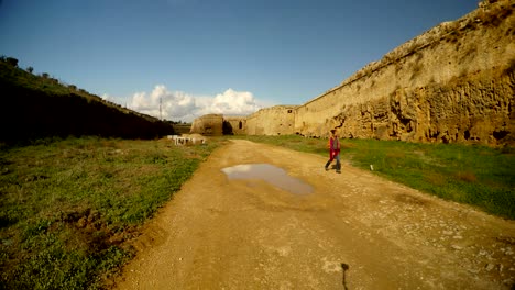 niña camina por un camino de tierra en un profundo foso de la fortaleza medieval de famagusta