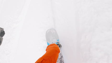 POV-shot-of-snowboarder-riding-down-a-mountain