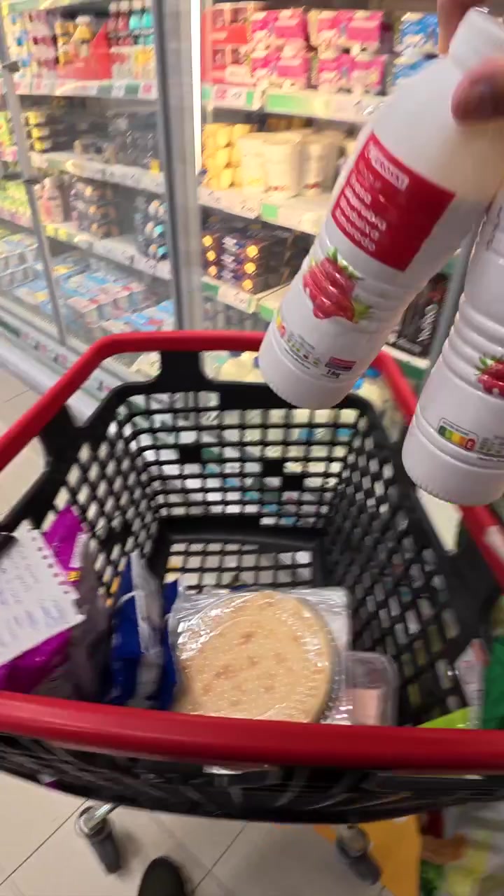 Persona che fa la spesa con lista e carrello al supermercato