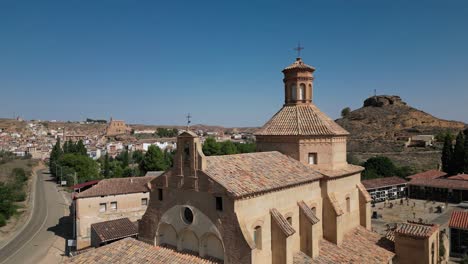historic church and cemetery overlooking a village in an arid landscape