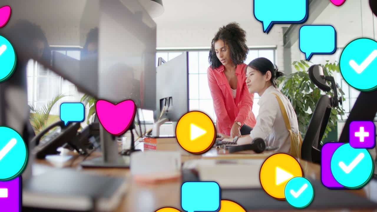 Mentore che indica e impiegato che digita, causando un'inondazione di icone social sulla scrivania per mostrare il lavoro di marketing.