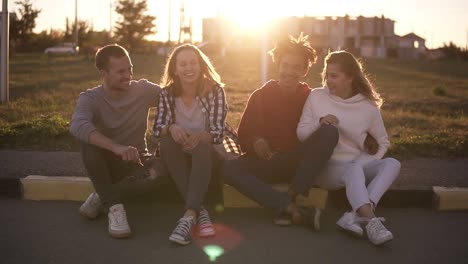 Two-Young-Mixed-Raced-Couples-Sit-On-The-Curb-On-The-Street