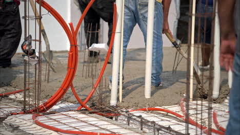 movimiento lento de un trabajador de construcción latino mexicano aplanando la mezcla de hormigón fresco con una pala para hacer la losa