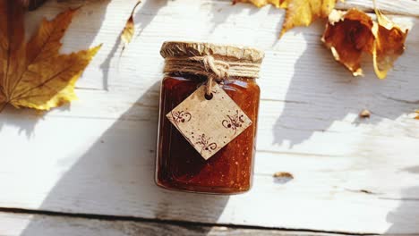 autumn leaves and pumpkin spice jam on rustic table