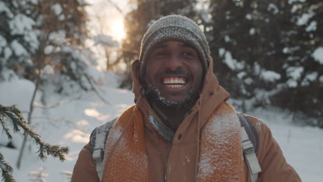 happy man hiking in snowy forest