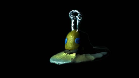 clay figure of spaceship spinning over black background - outer space concept - studio shot