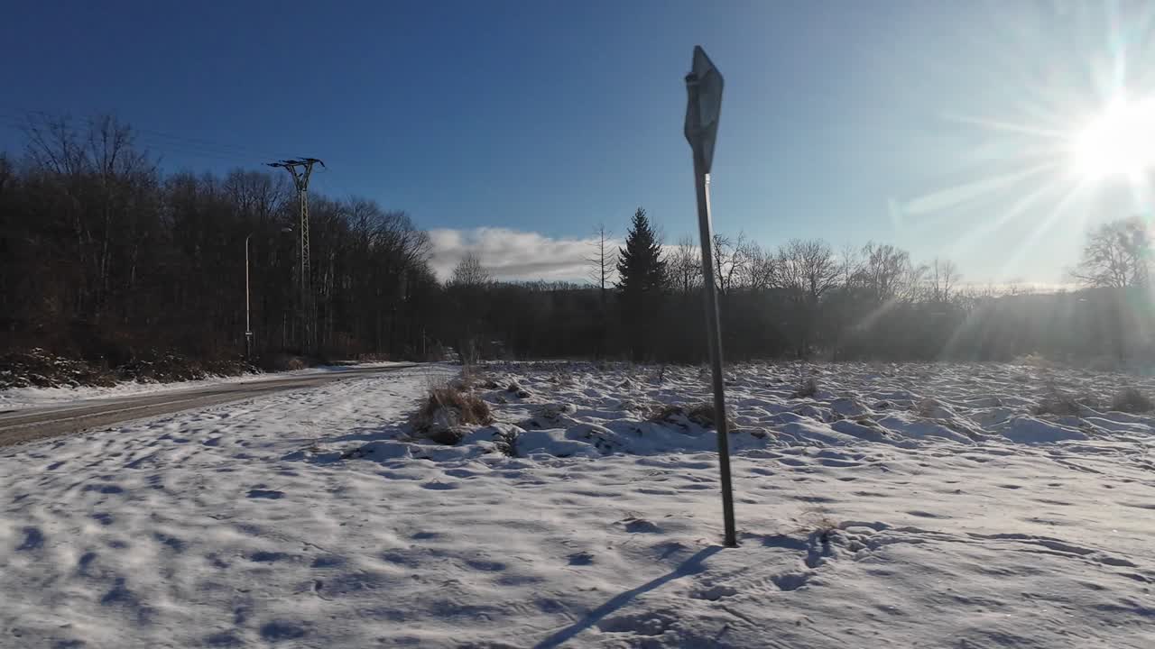La driving plate mostra un paesaggio invernale innevato durante un viaggio in auto in una zona rurale europea