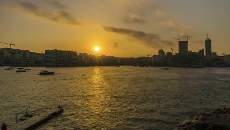 Goldene-Stunde-In-Sliema-Mit-Menschen,-Die-Schwimmen,-Malta,-Zeitraffer