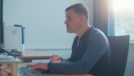 busy european dutch caucasian white man male adult model working in the office job on desktop workspace on pc keyboard and tablet, digital film look