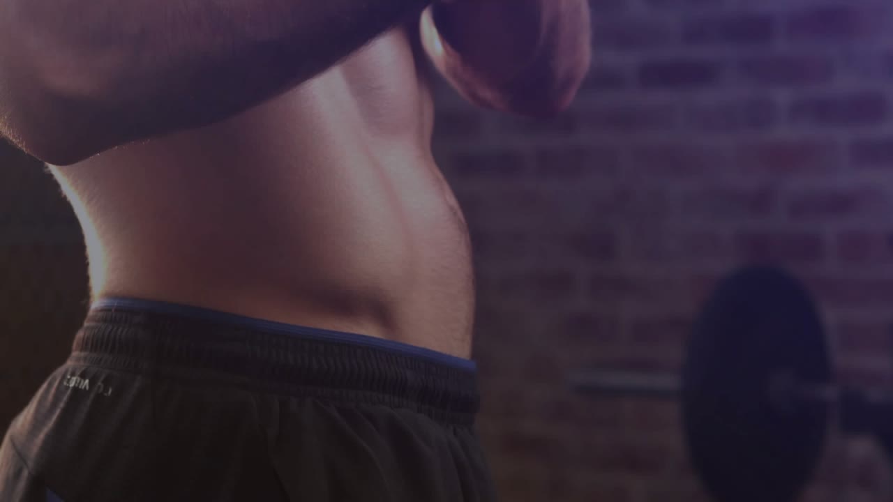Uomo che unisce le mani in palestra, contraendo gli addominali, evidenziando la definizione muscolare con un'animazione in sovrimpressione