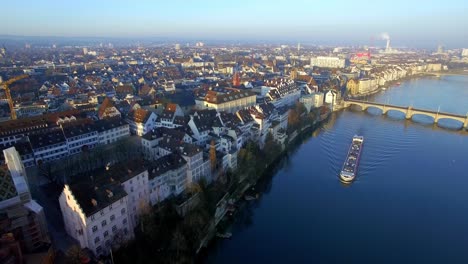 embark on a breathtaking drone journey from basel's skyline, gliding past the iconic minster, and unveiling a mesmerizing sunrise scene with a cargo ship below