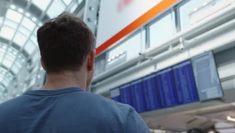 guy looking at flight schedule board