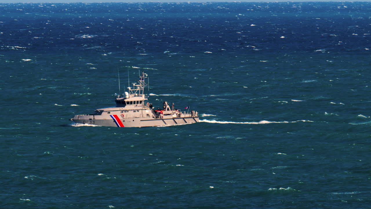 Nice, France - March 17, 2025: A grey, customs boat with the flag of France moving alone on the sea