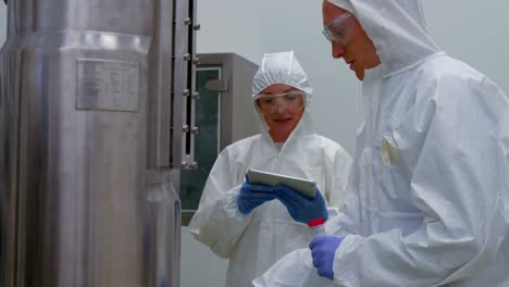 scientists in protective suits working together