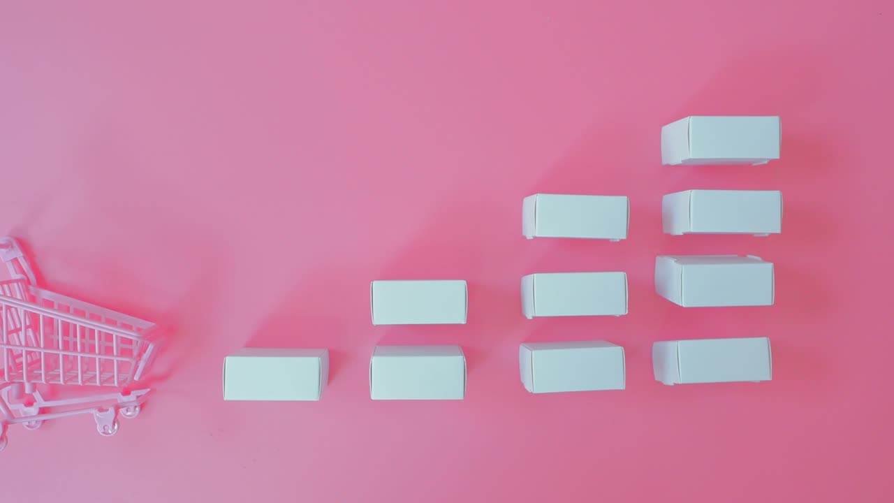 핑크색 배경에 트롤리와 제품 상자에서 마케팅 전략 또는 쇼핑 개념.