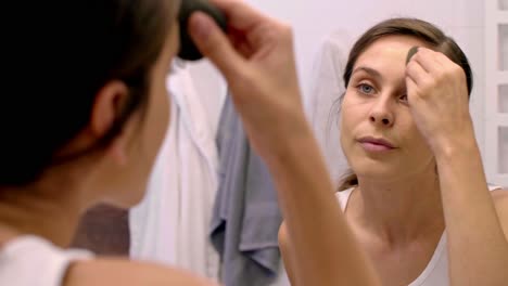 mujer haciendo el maquillaje en el baño