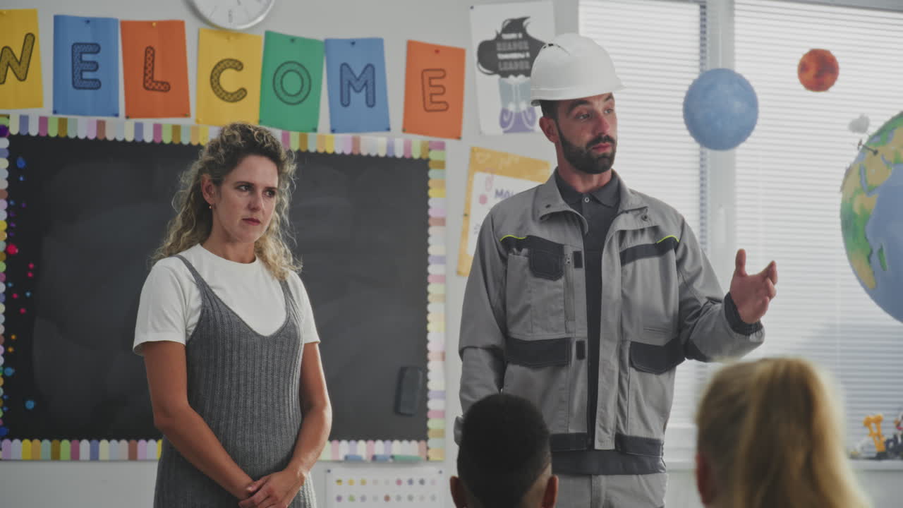 Construction Worker in Uniform Speaking to Curious Students About Work on Construction Site