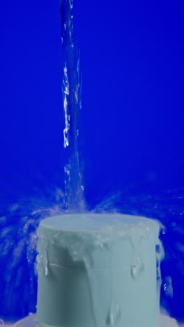 water pouring onto a light blue cylindrical object