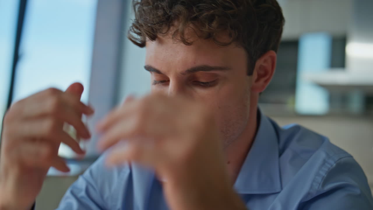 Tired worker drinking coffee working at desk closeup. Overloaded professional