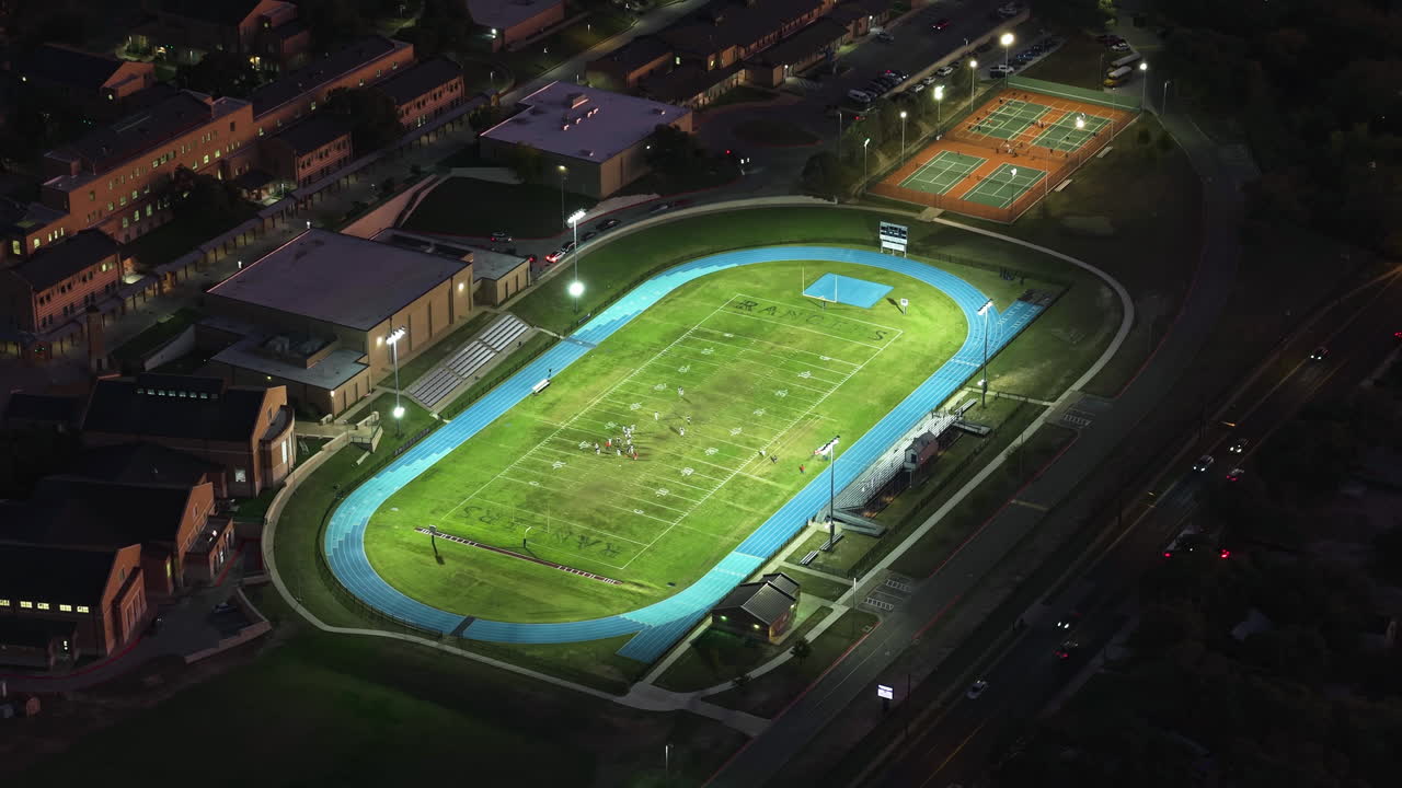 drone inclinándose hacia un campo de fútbol iluminado, por la noche en austin, texas, ee.uu.