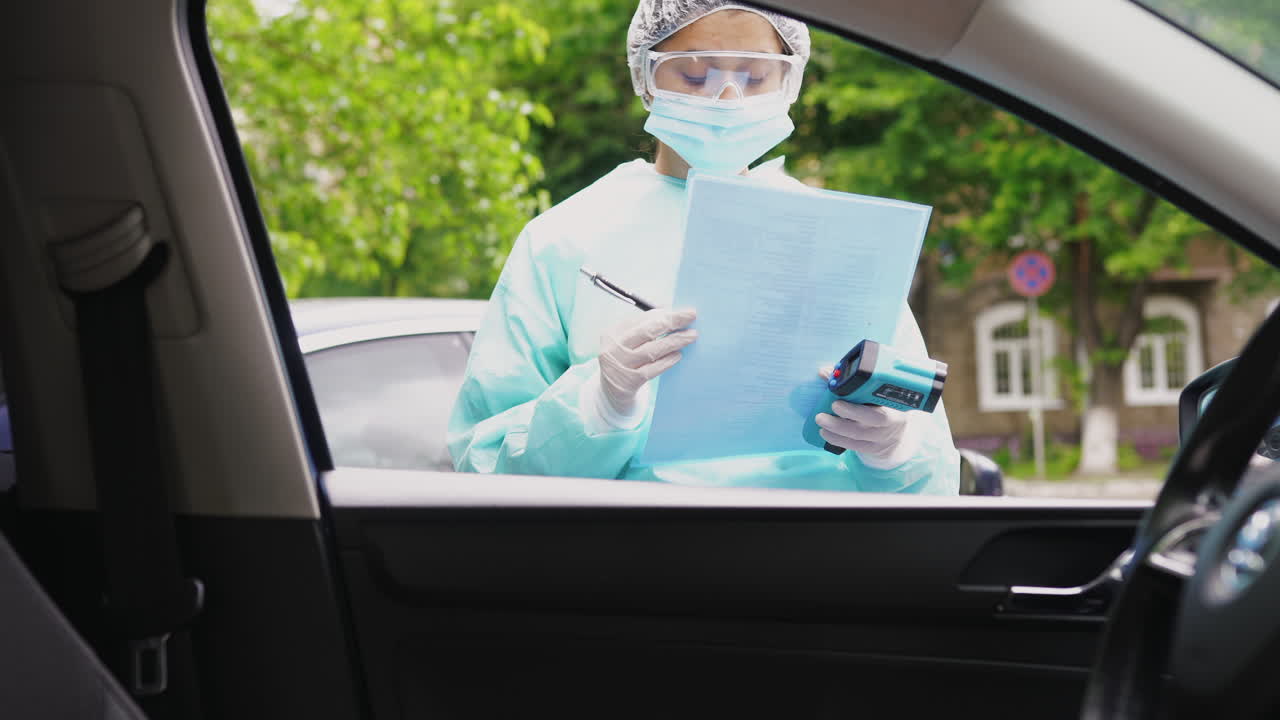 profesional médico que lleva a cabo un control de temperatura en un automóvil