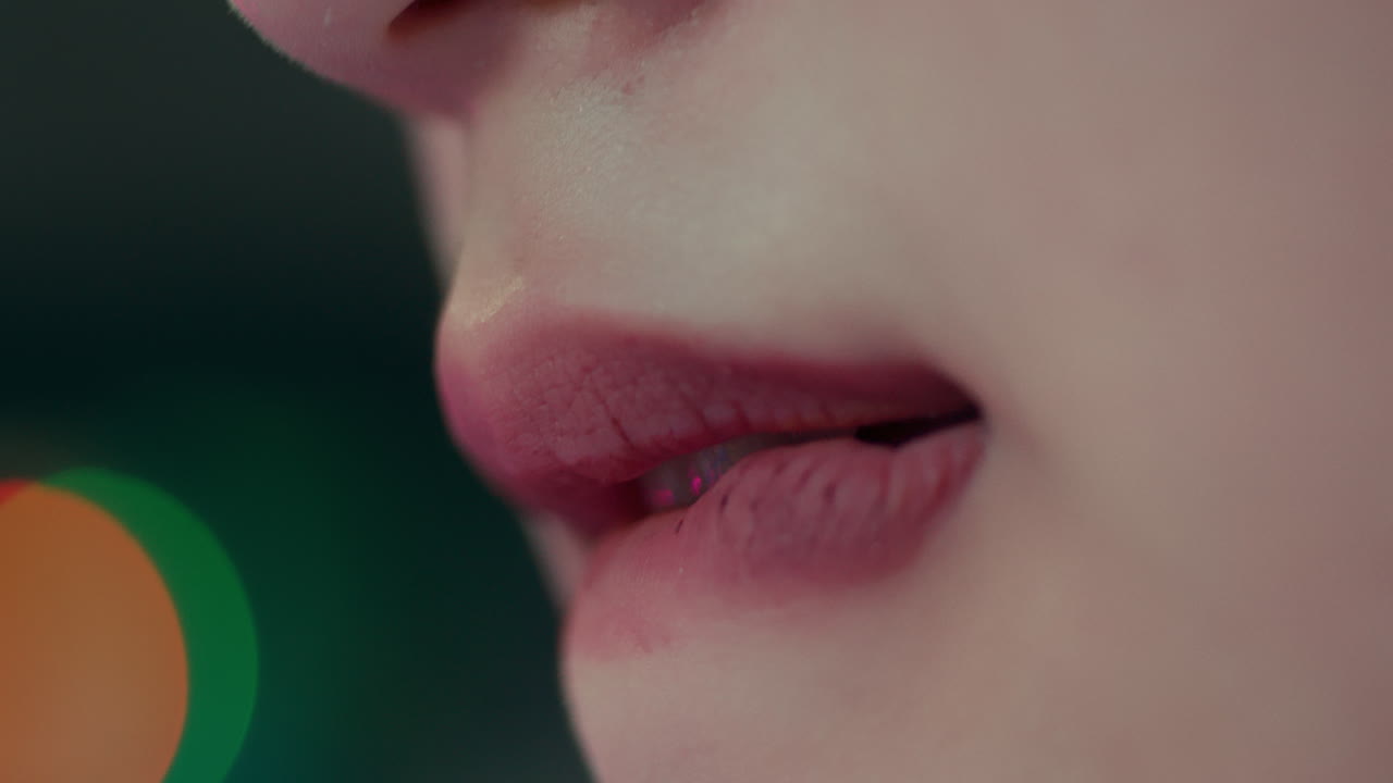 bolsos femeninos labios y mordeduras chupando en ellos con luces bokeh detrás, disparo detallado