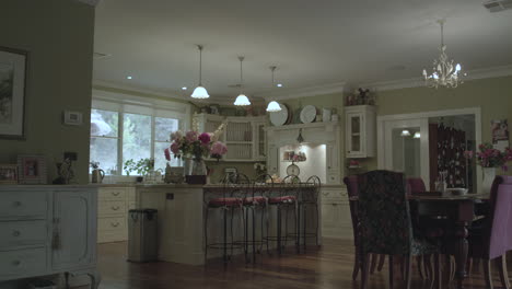 wide tracking shot of country styled kitchen with fresh flowers on an autumn afternoon