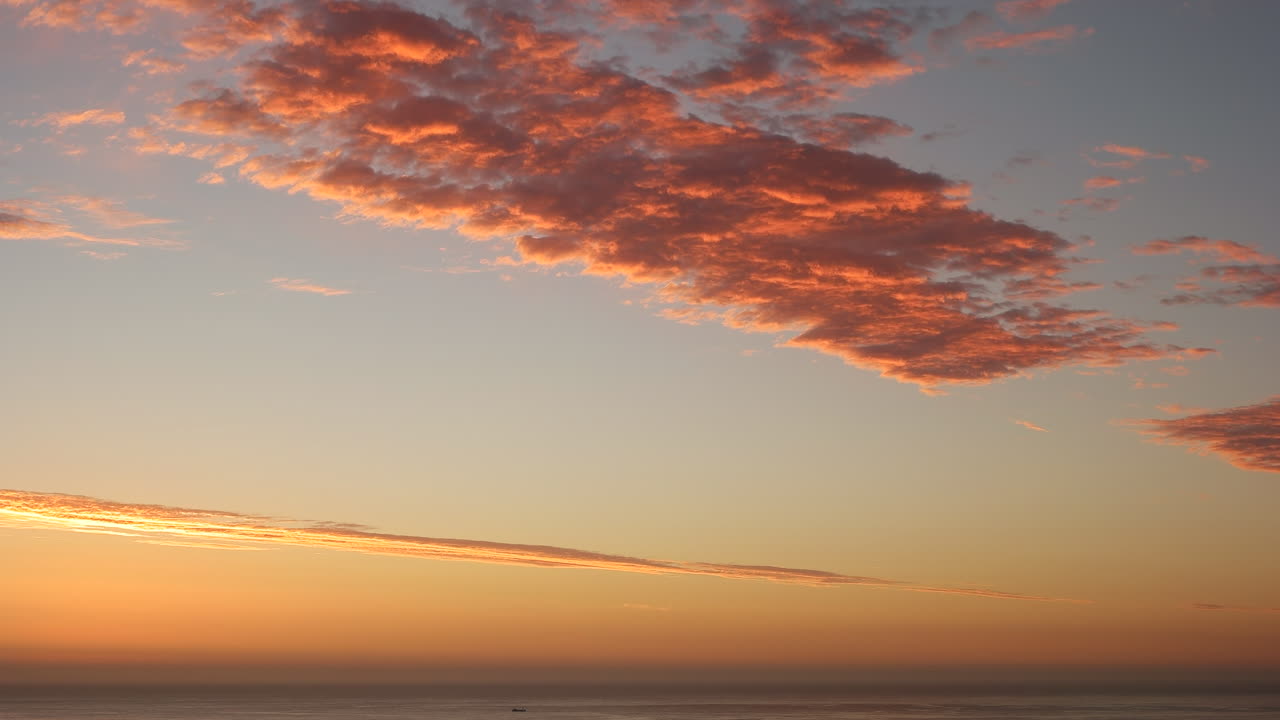 Stille hav med smuk orange himmel og skyer ved solnedgang