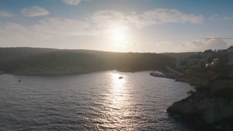 Antenne---Helles-Abendsonnenlicht-Beleuchtet-Den-Weg-Am-Küstengewässer,-Mallorca