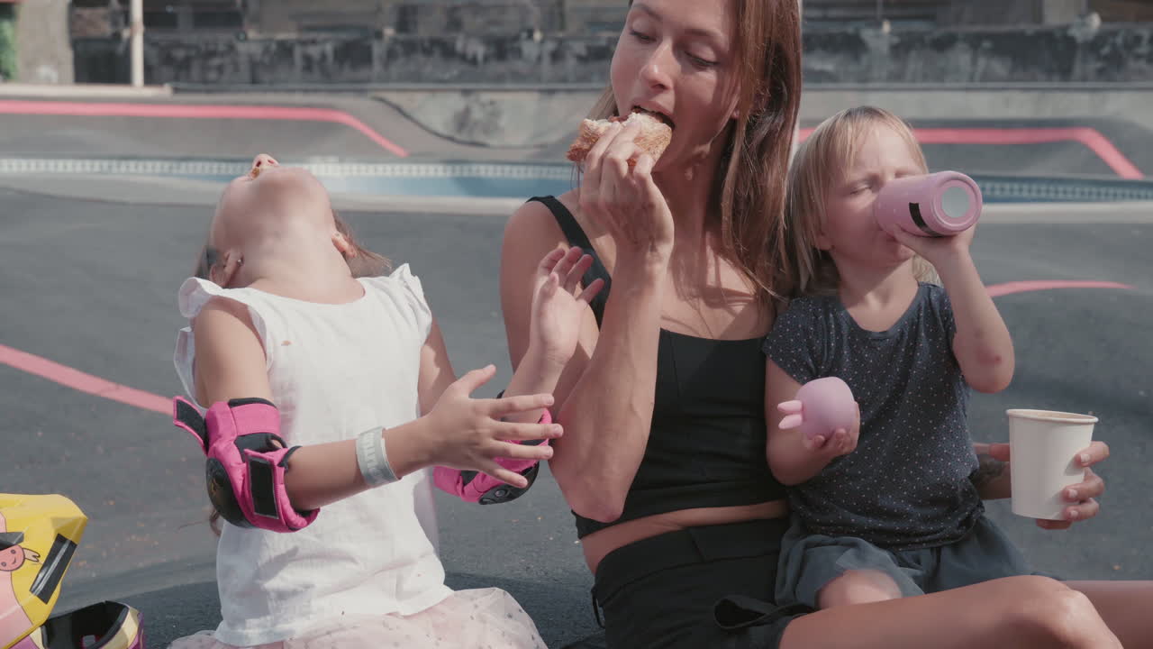 madre e hijos comiendo al aire libre