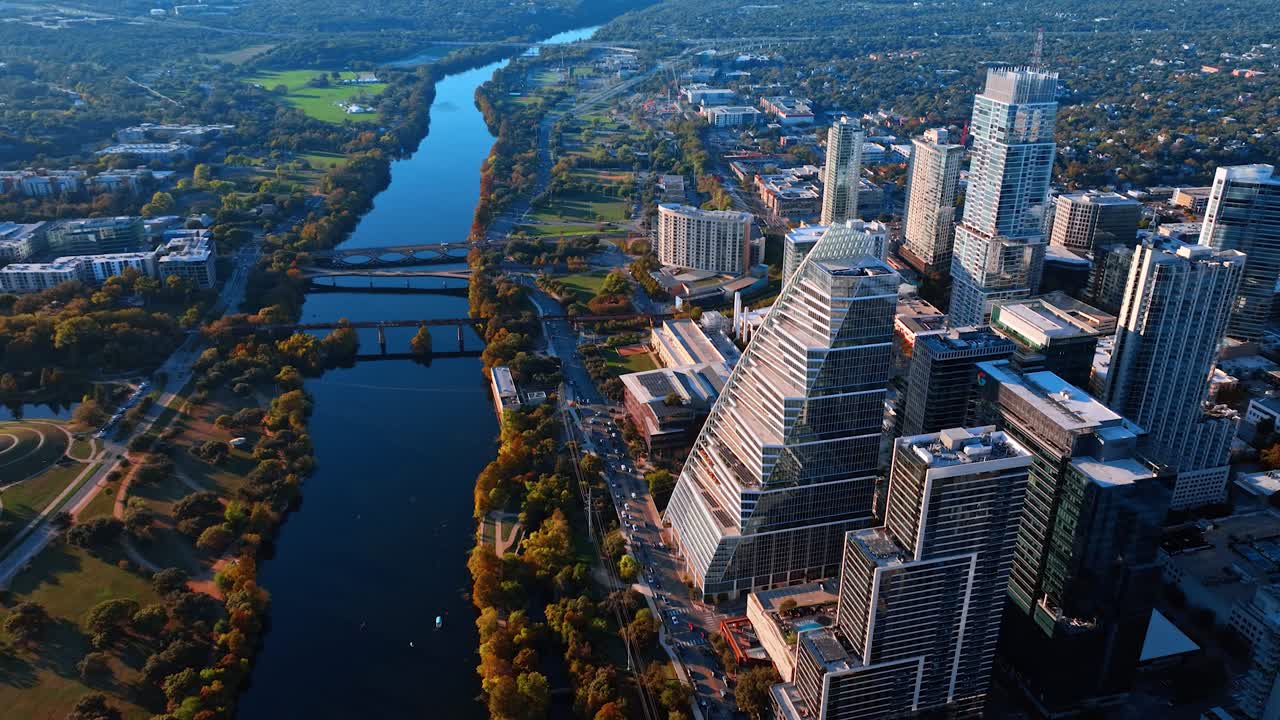 Austin, USA, 21 novembre 2025: Prospettiva aerea dello skyline di Austin lungo il fiume Colorado. Vista dall'alto di moderni edifici in vetro, fiume, ponti e parchi verdi durante l'ora d'oro nel centro di Austin.