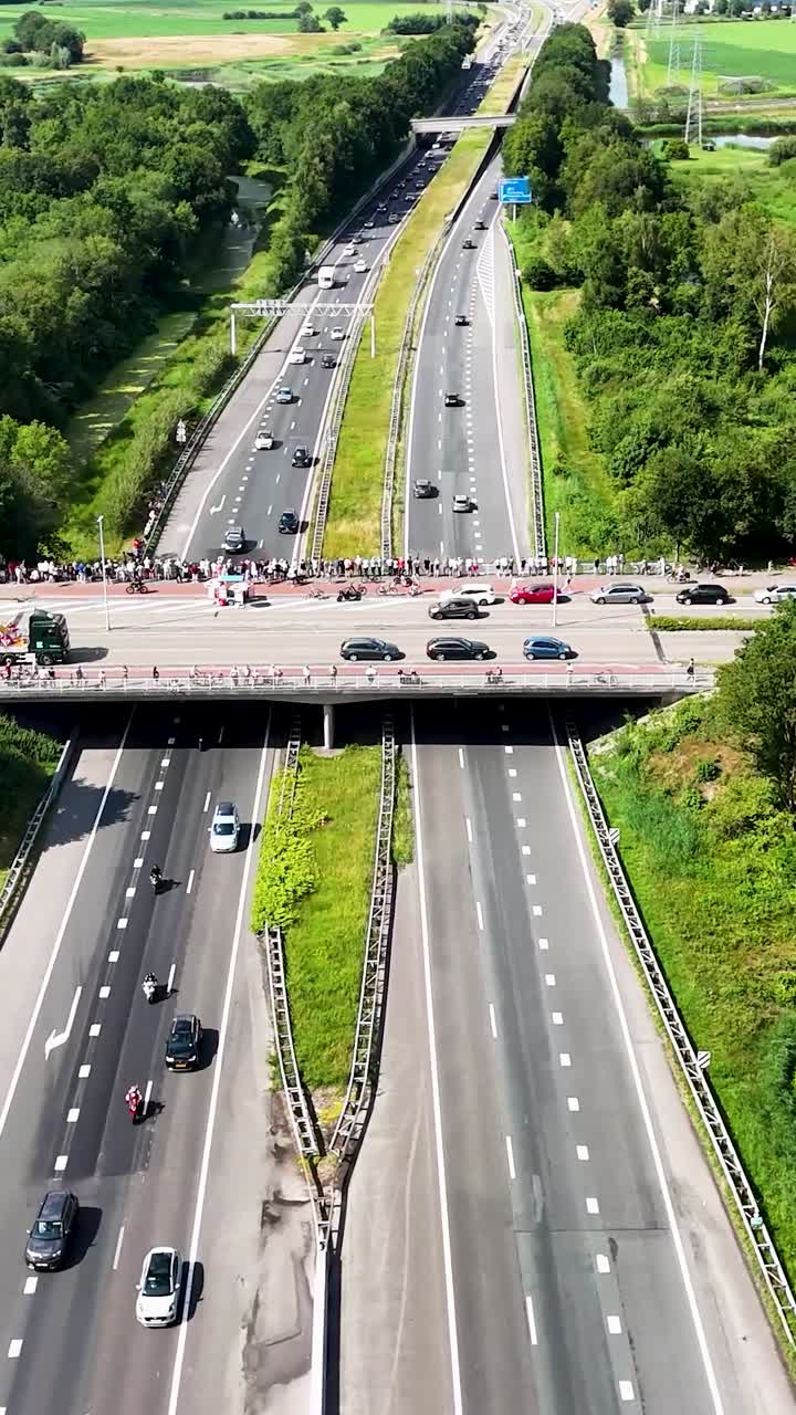 Aerial view of highway traffic and people gathered on an overpass