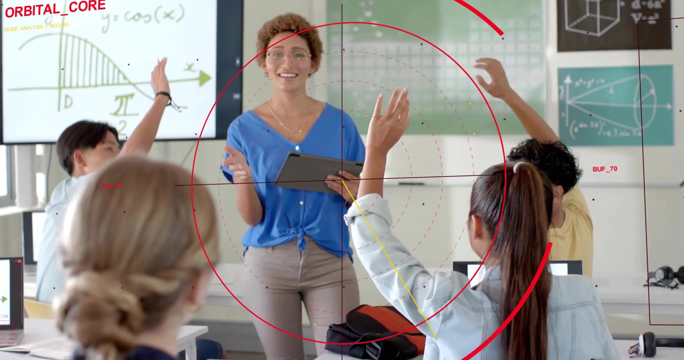 Insegnante in classe con tablet che chiede alla telecamera di puntare il mirino su di lei, mentre gli studenti alzano le mani per rispondere.