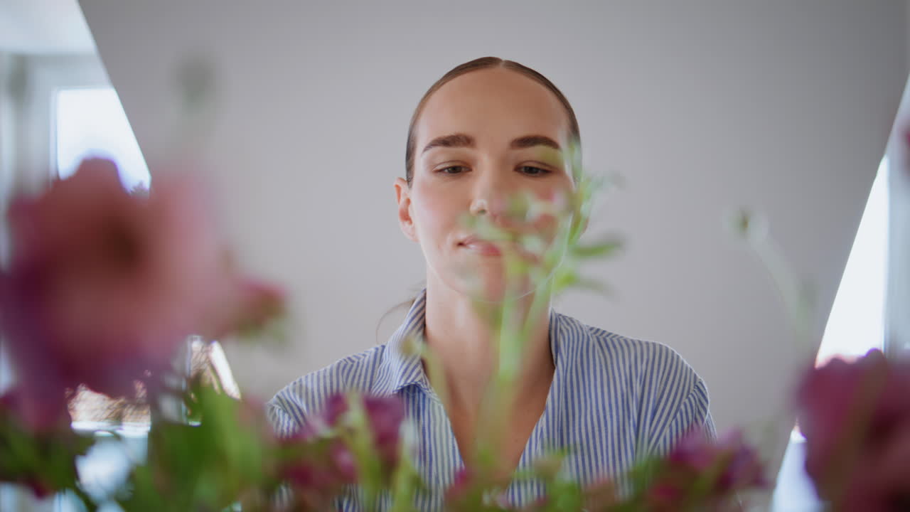 Smiling model arranging floral compositions apartment closeup. Girl with flowers