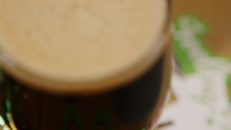 close up on head of glass of irish stout in pint glass at party celebrating st patrick's day