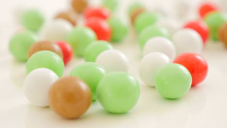 colorful button-shaped candies on white reflective surface 4k