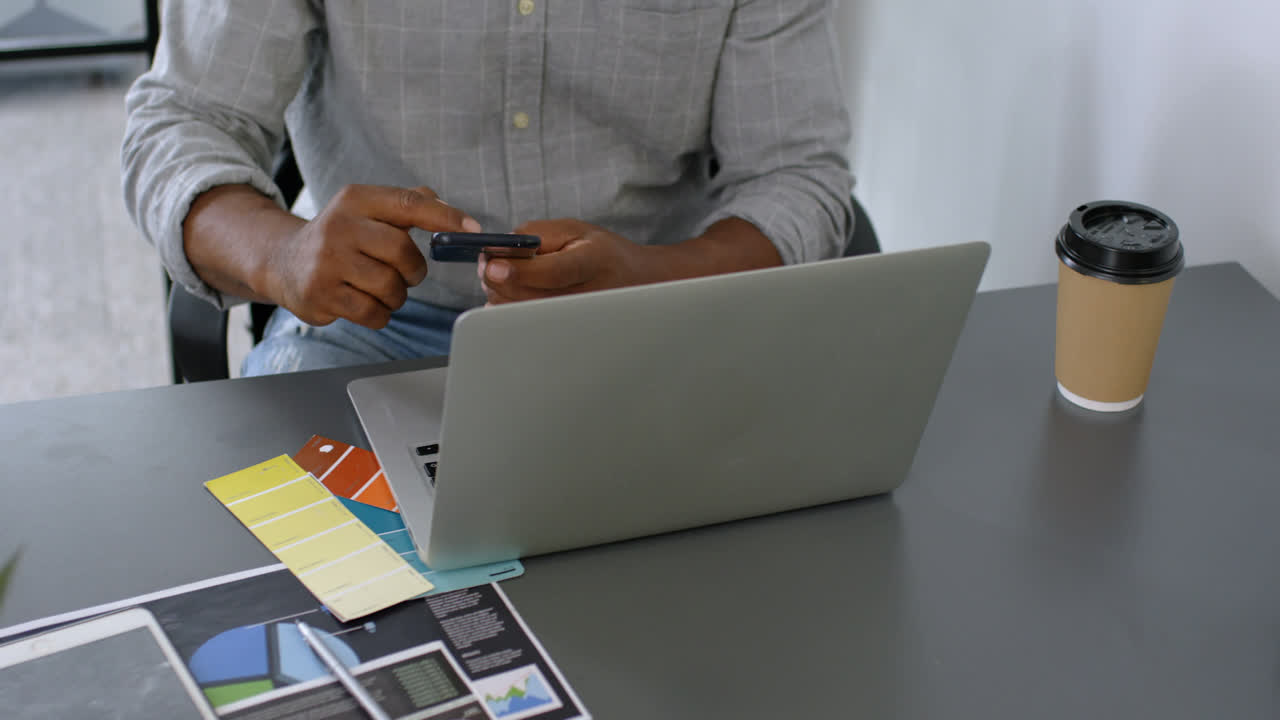 Man having coffee while using mobile phone on desk 4k