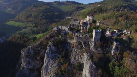 orbiting drone shot of a castle on a hill at sunset, flying right while panning left, 4k uhd