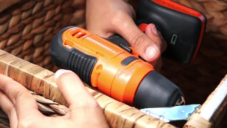 person handling a power drill in a basket