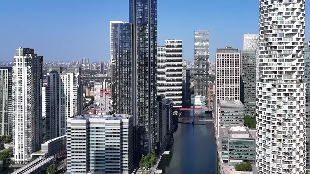 Drone footage of Canary Wharf financial district, capturing iconic high-rise architecture, riverside scenes, train passing over bridge and the dynamic urban energy of East London’s skyline
