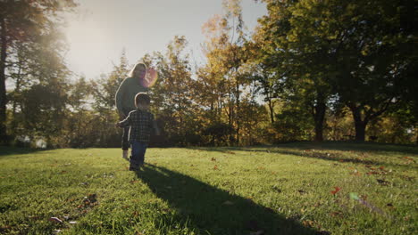 Mom-runs-after-her-baby-in-the-meadow-in-the-rays-of-the-setting-sun.-Happy-motherhood