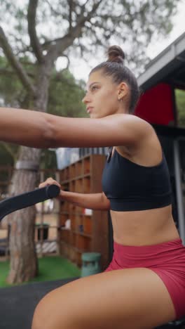 woman trains on an exercise machine at an outdoor gym