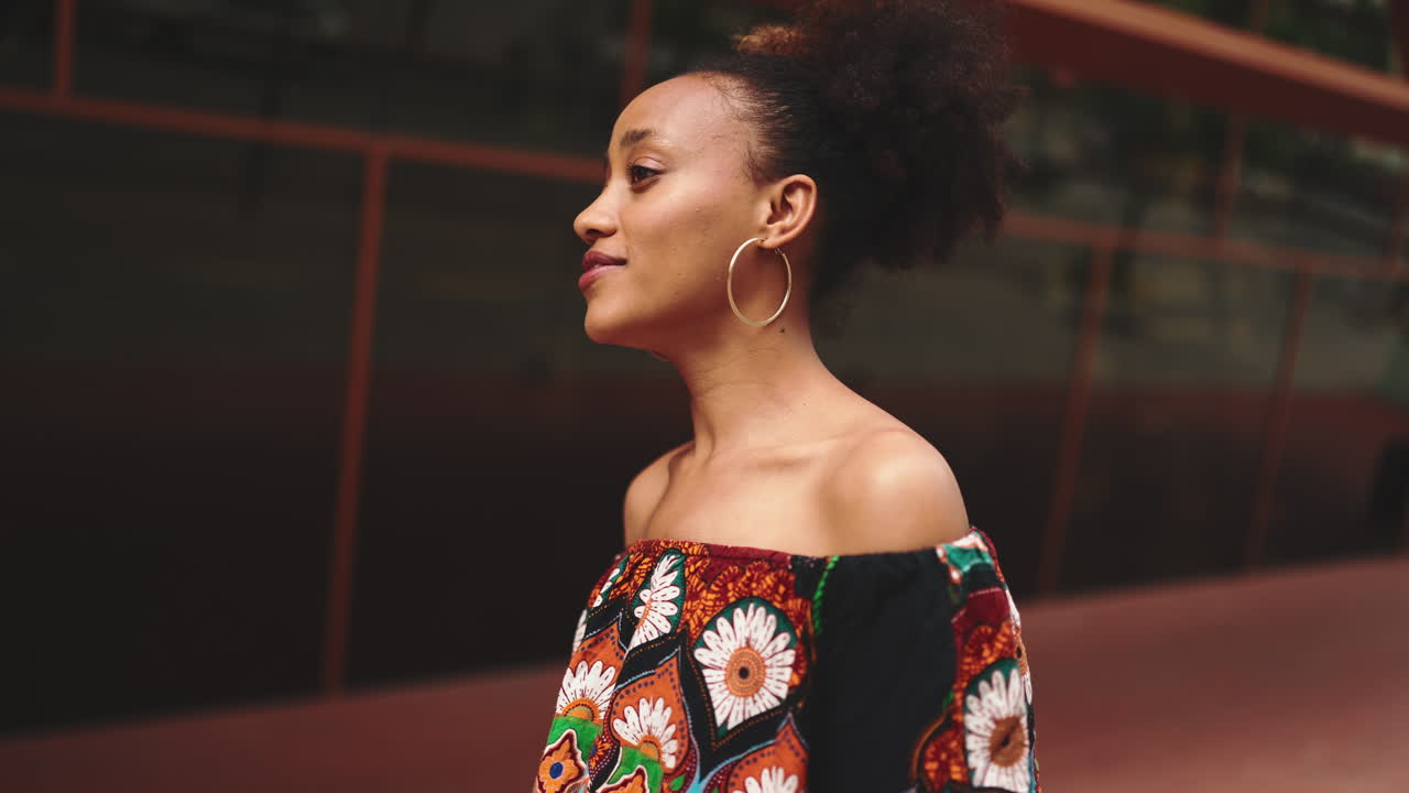 Ritratto di una donna con capelli afro e top con stampa etnica