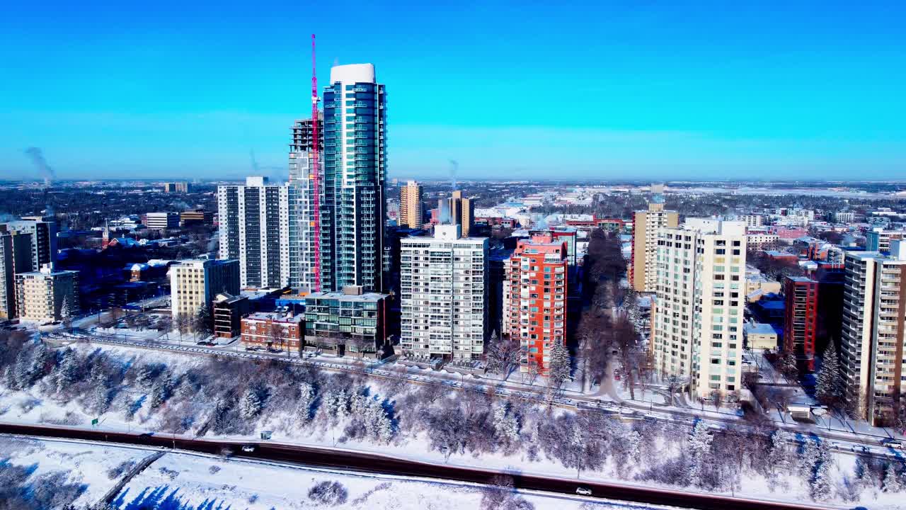 deriva aérea inversa de las casas de gran altura más lucrativas de edmonton durante el clima frío extremo del invierno nieve que cubre victoria park cliff road en 100 ave nw en un cielo despejado y soleado como desarrollo de la ciudad l2-2