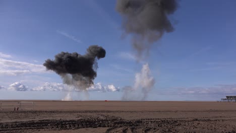 explosions on a beach with black smoke uk 4k